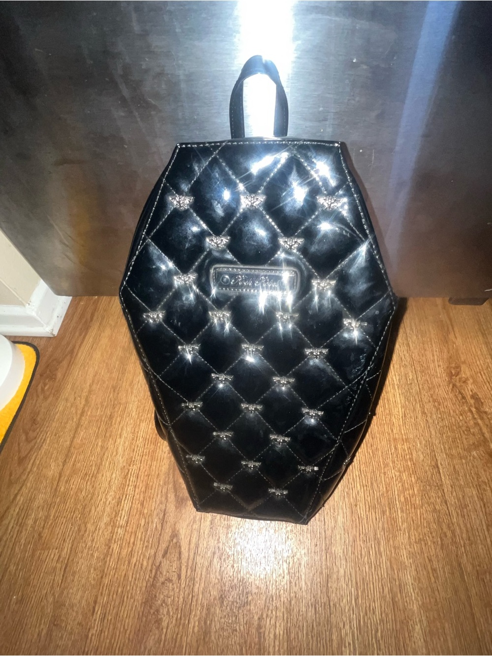 Rock Rebel black coffin-shaped backpack with silver bat embellishments.